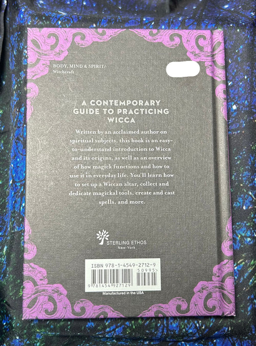 Back cover of a book titled 'A Contemporary Guide to Practicing Wicca' with decorative purple border on a textured surface.